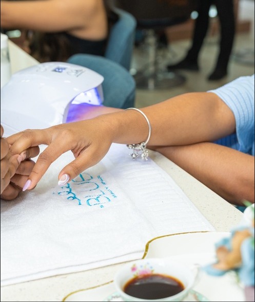 Manos durante un manicure bajo la lámpara UV