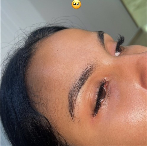 Depilación de cejas con hilo, clienta con los ojos cerrados